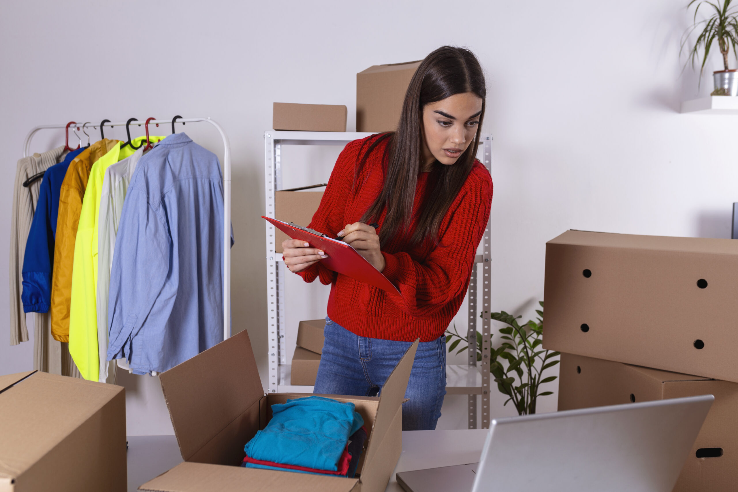 owner of small business packing product in boxes, preparing it for delivery. Women packing package with her products